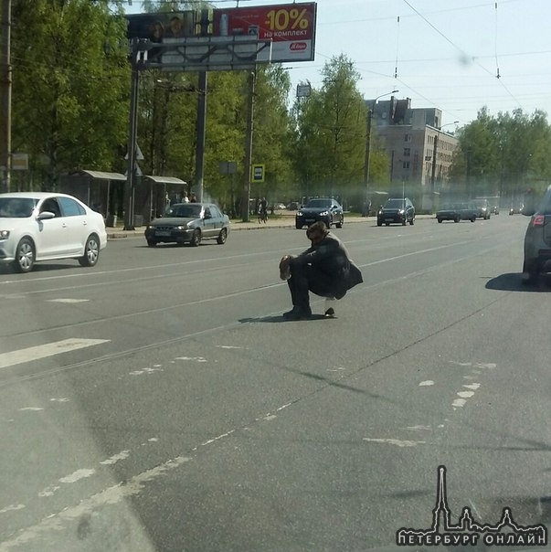 На пересечении Светлановского пр. И тихорецкого сидит на дороге человек по середине дороги.