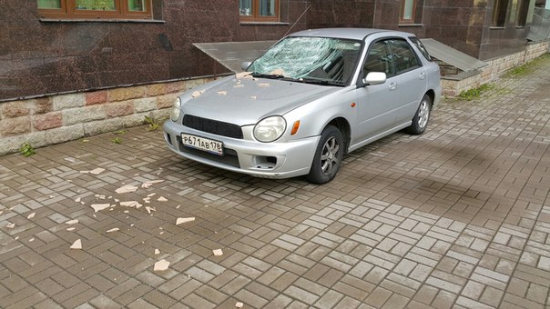 Порывы ветра сорвали плитку с фасада дома на Краснопутиловской прямо в лобовое Субарику