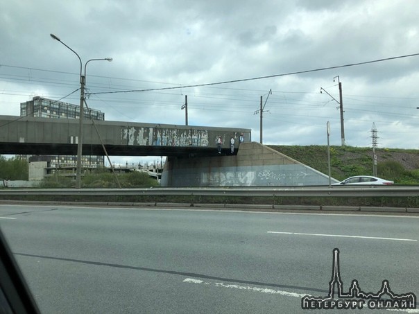 Странная картина на Московское шоссе у съезда с КАД. На Ж/Д мосту висят повешение манекены.