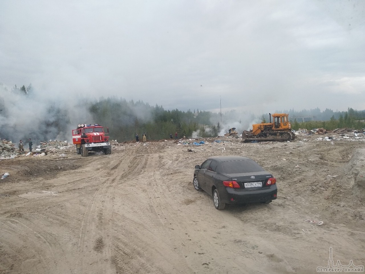 В городе Мурино на территории промзоны горит незаконная свалка. Пожарные пытаются погасить . Самосва...