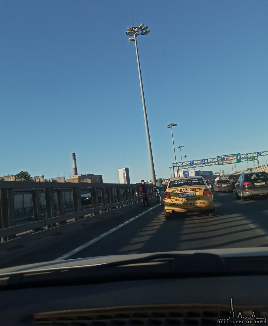 На внешней стороне КАД перед Обуховским мостом в левой полосе стоят три машинки. Желтое такси постав...