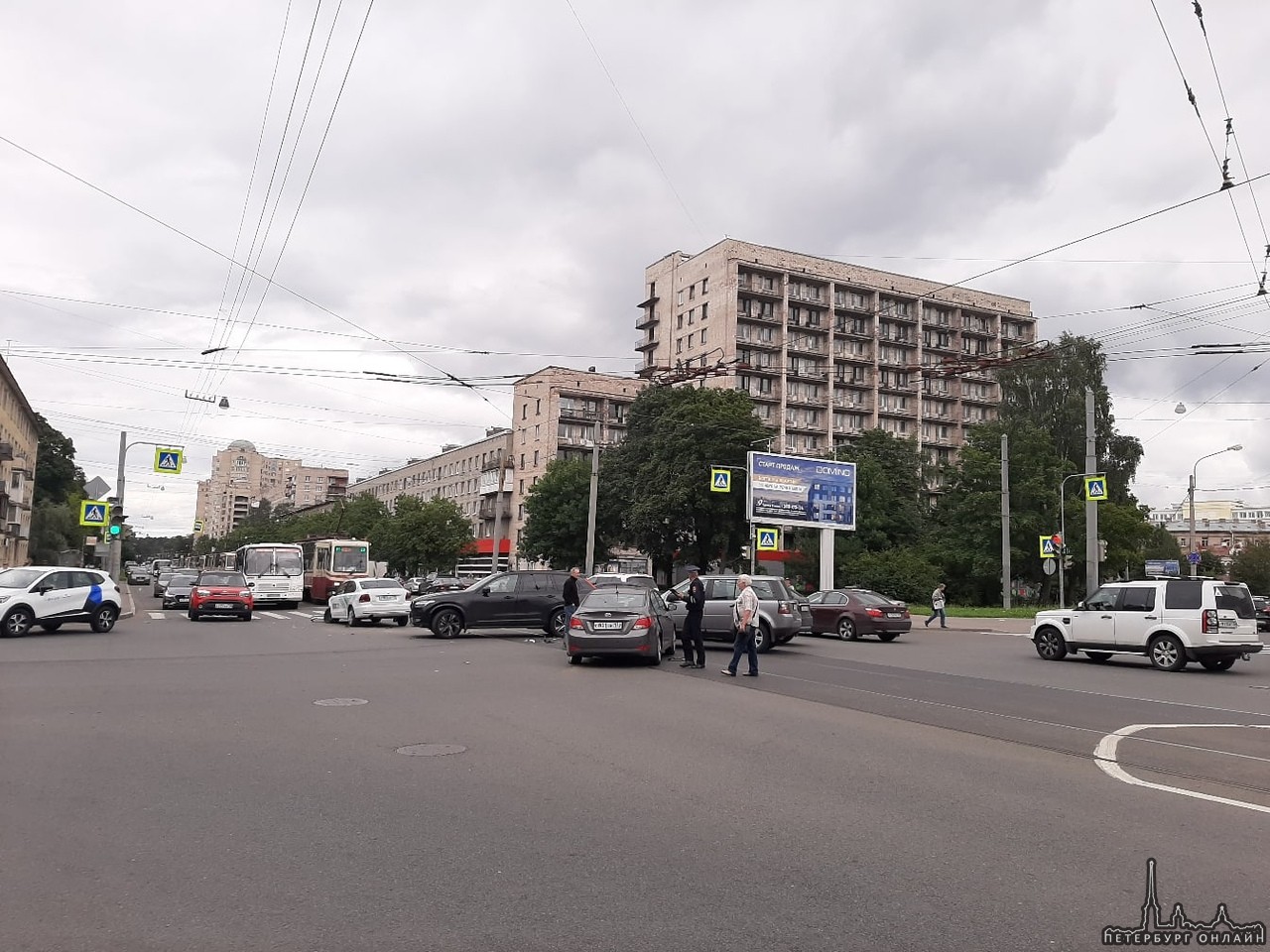 Пересечение Торжковской и Белоостровской. Трамваи стоят в обе стороны. Каршеринг со всех сторон помя...