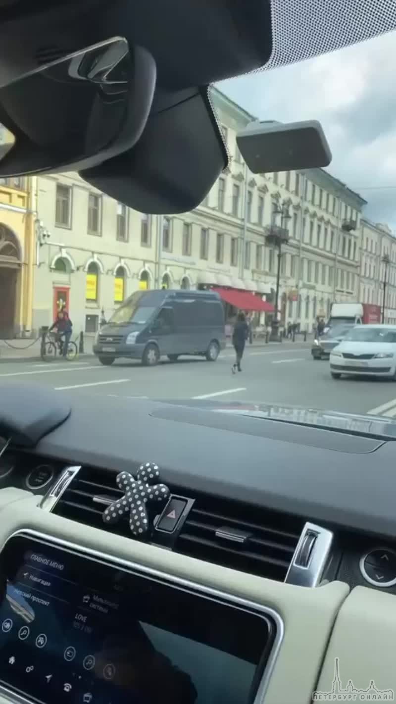 Женщина с маской в руках бегает по проезжей части на Невском проспекте и останавливает все машины.